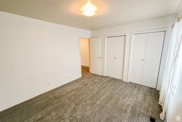 88 W 50 S Unit V-1, Centerville, UT 84014 - unfurnished bedroom with carpet floors, visible vents, and two closets
