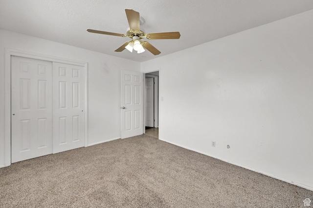 unfurnished bedroom with baseboards, carpet floors, a ceiling fan, and a closet