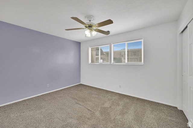 unfurnished bedroom featuring baseboards, carpet floors, a closet, and ceiling fan