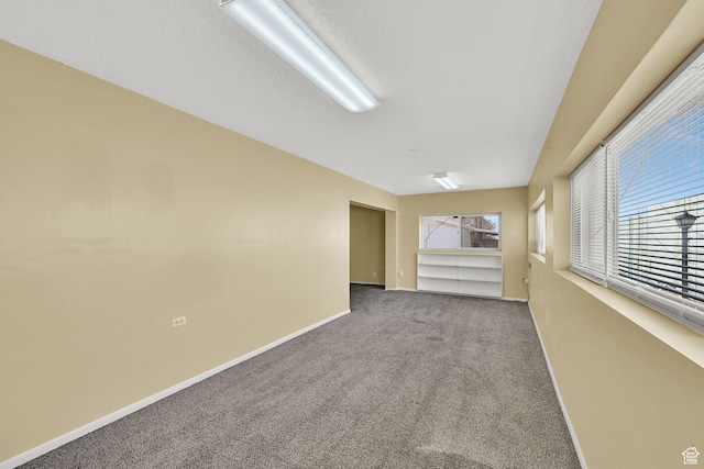carpeted spare room with baseboards