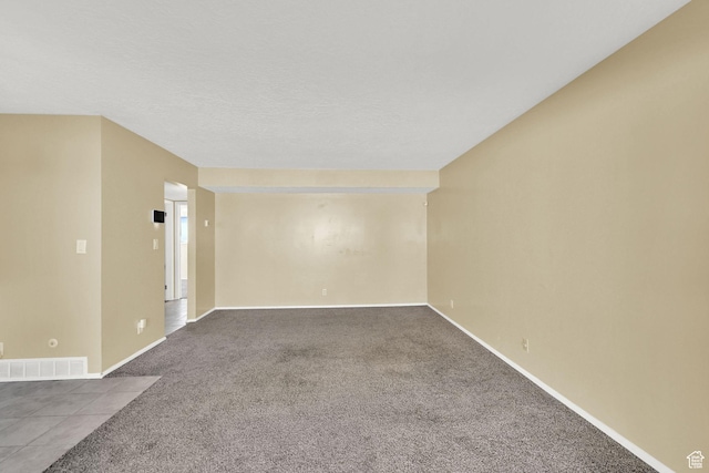 carpeted empty room with visible vents and baseboards