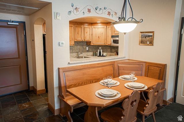 840 W Bigler Ln N Unit 3013, Midway, UT 84049 - kitchen featuring arched walkways, tasteful backsplash, light countertops, stainless steel microwave, and hanging light fixtures
