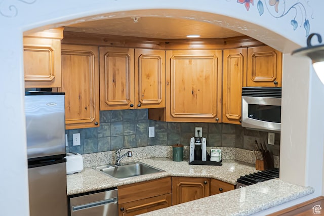 840 W Bigler Ln N Unit 3013, Midway, UT 84049 - kitchen featuring appliances with stainless steel finishes, brown cabinetry, a sink, and backsplash