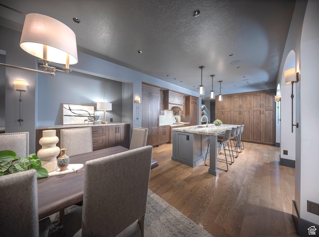 6153 E Last Monument Cir, Salt Lake City, UT 84108 - dining area featuring recessed lighting, a textured ceiling, arched walkways, and light wood-style floors