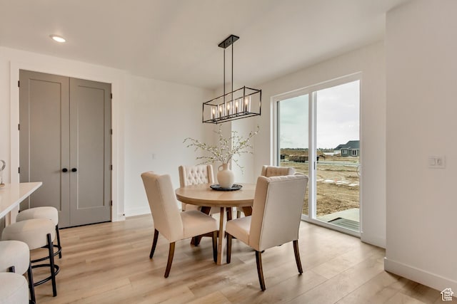 dining room with recessed lighting, light wood finished floors, baseboards, and a notable chandelier