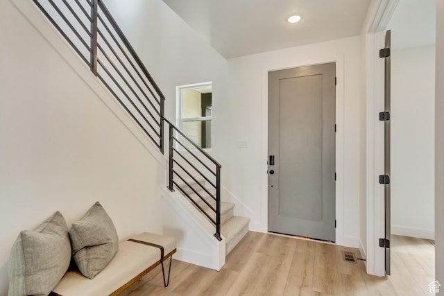 entryway with recessed lighting, visible vents, light wood-type flooring, baseboards, and stairs