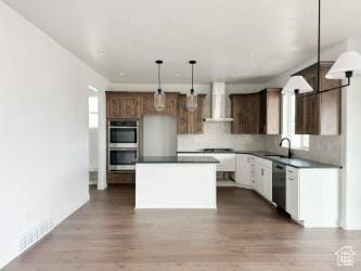 5644 W 7340 S, West Jordan, UT 84081 - kitchen with wall chimney range hood, stainless steel appliances, dark countertops, and a kitchen island