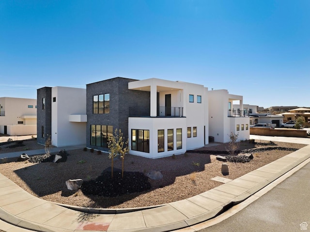 view of front facade featuring a balcony and stucco siding