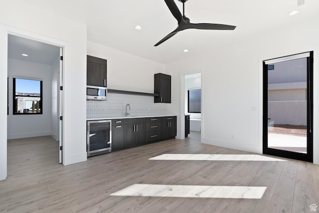 1461 W Canyon Tree Dr, St George, UT 84770 - kitchen featuring light wood finished floors, tasteful backsplash, light countertops, a sink, and beverage cooler