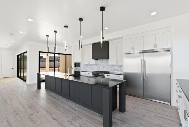 1461 W Canyon Tree Dr, St George, UT 84770 - kitchen with dark countertops, a sink, decorative light fixtures, and built in appliances