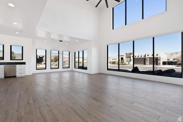 1461 W Canyon Tree Dr, St George, UT 84770 - unfurnished living room with ceiling fan, recessed lighting, baseboards, light wood-type flooring, and a residential view
