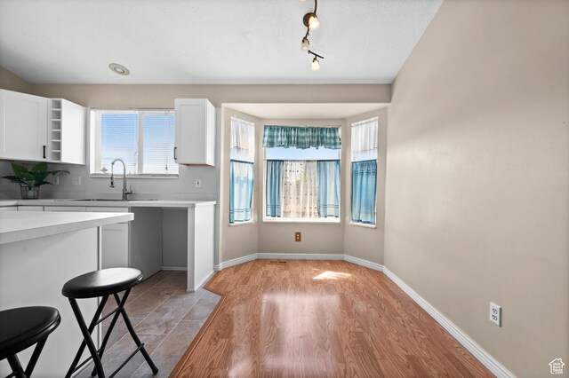 2337 W 2075 N, Clinton, UT 84015 - kitchen featuring light countertops, white cabinetry, a breakfast bar, and rail lighting