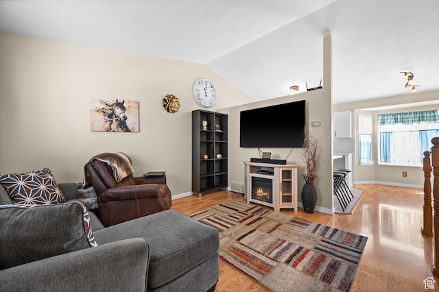 2337 W 2075 N, Clinton, UT 84015 - living room with light wood-type flooring, lofted ceiling, and a lit fireplace