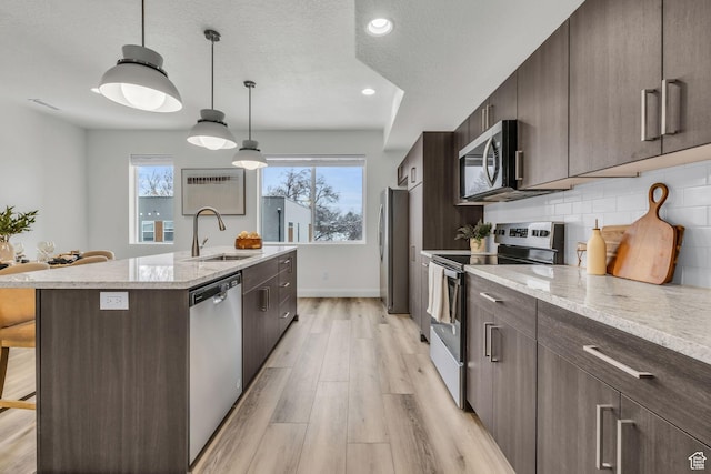239 E Burch Creek Pl S, Ogden, UT 84405 - kitchen featuring a kitchen island with sink, dark brown cabinetry, stainless steel appliances, and a sink