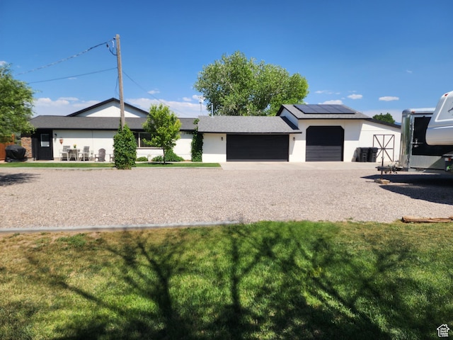 140 E 100 S, Centerfield, UT 84622 - view of front of home with a garage, a front yard, roof mounted solar panels, and stucco siding