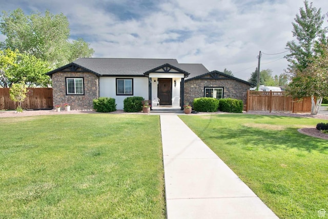 view of front of house with stone siding, a front lawn, and fence