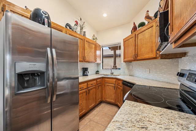 kitchen featuring light tile patterned floors, stainless steel appliances, tasteful backsplash, and a sink