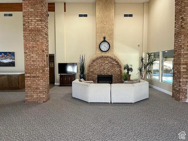 living area with carpet floors, a high ceiling, and a fireplace