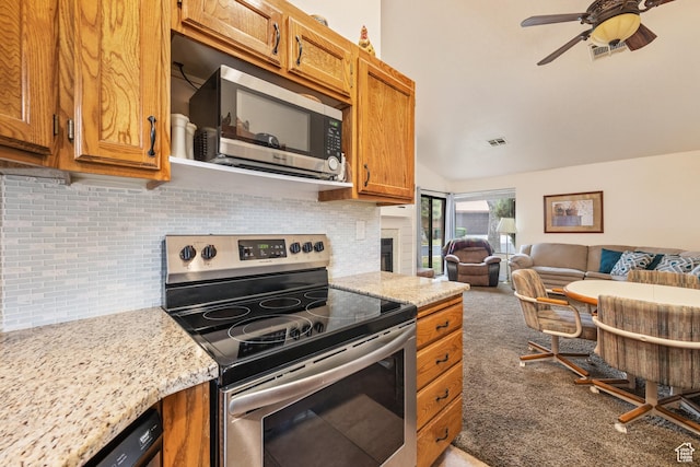 kitchen featuring brown cabinets, stainless steel appliances, tasteful backsplash, open floor plan, and carpet flooring
