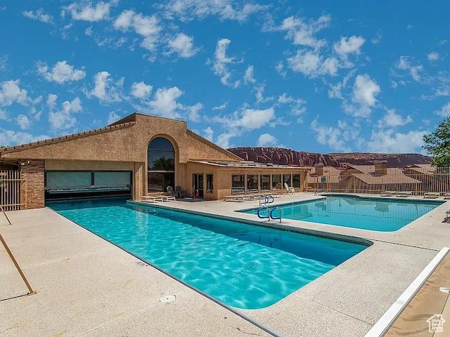 community pool featuring a patio area and fence