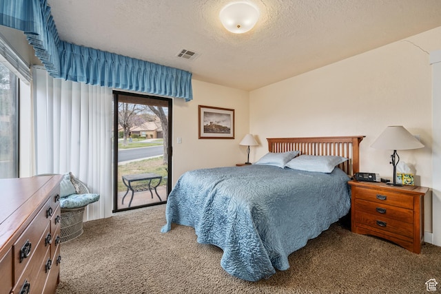 bedroom with a textured ceiling, carpet floors, visible vents, and access to exterior