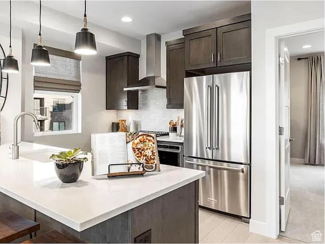 6785 Silver Creek Dr N, Park City, UT 84098 - kitchen with stainless steel appliances, wall chimney exhaust hood, a sink, dark brown cabinets, and light countertops