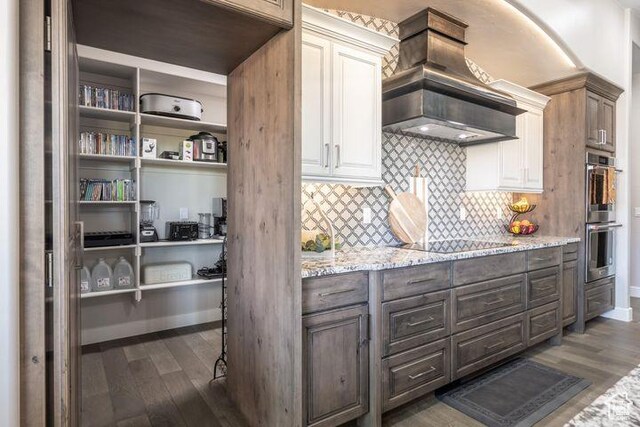 3052 N Snow Canyon Pkwy Unit 201, St George, UT 84770 - kitchen featuring light stone countertops, black electric stovetop, custom exhaust hood, and dark brown cabinets