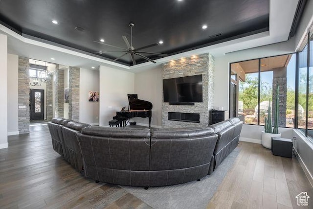 3052 N Snow Canyon Pkwy Unit 201, St George, UT 84770 - living area featuring a stone fireplace, a tray ceiling, and wood finished floors