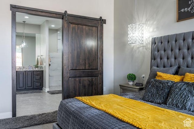 3052 N Snow Canyon Pkwy Unit 201, St George, UT 84770 - bedroom featuring connected bathroom, baseboards, and a barn door