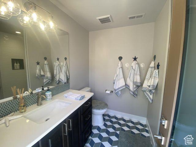 3052 N Snow Canyon Pkwy Unit 201, St George, UT 84770 - full bathroom featuring toilet, baseboards, visible vents, and vanity