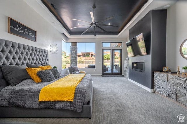 3052 N Snow Canyon Pkwy Unit 201, St George, UT 84770 - carpeted bedroom featuring baseboards, a glass covered fireplace, access to exterior, a tray ceiling, and recessed lighting