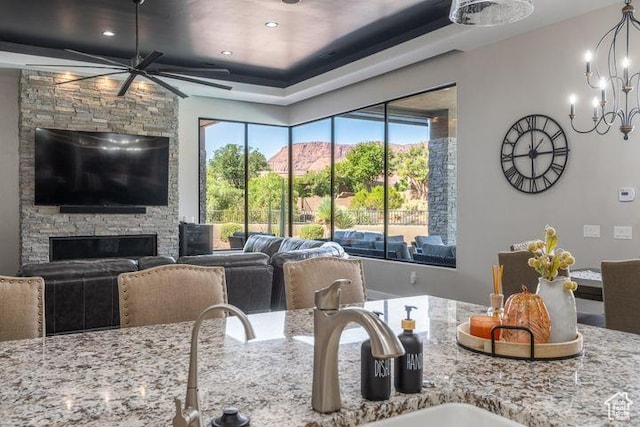 3052 N Snow Canyon Pkwy Unit 201, St George, UT 84770 - kitchen featuring light stone counters, open floor plan, a sink, and a stone fireplace