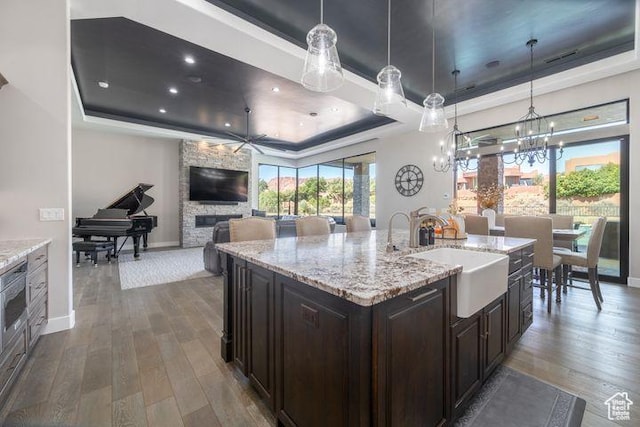 3052 N Snow Canyon Pkwy Unit 201, St George, UT 84770 - kitchen featuring hanging light fixtures, a center island with sink, a raised ceiling, and a sink