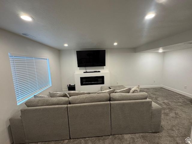 4834 E Hidden Steppe Bnd, Eagle Mountain, UT 84005 - carpeted living area with a glass covered fireplace, baseboards, visible vents, and recessed lighting