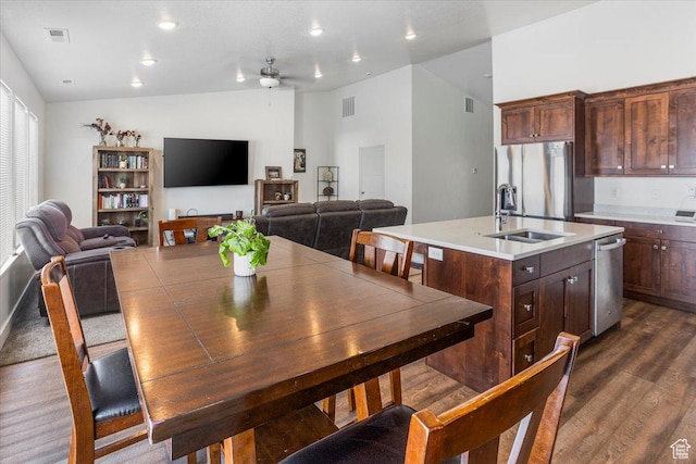 dining room with dark wood-type flooring, visible vents, a ceiling fan, and vaulted ceiling