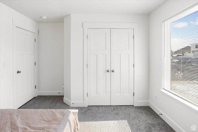 unfurnished bedroom with a closet, baseboards, and carpet