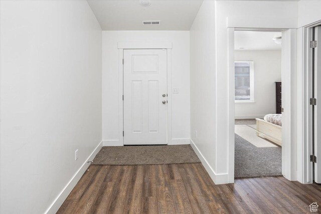 foyer entrance with visible vents, baseboards, and wood finished floors