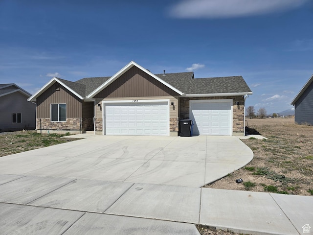 ranch-style house with an attached garage, stone siding, board and batten siding, driveway, and roof with shingles