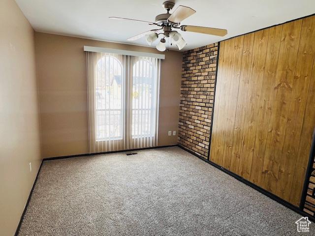 2299 W 5950 S, Roy, UT 84067 - spare room featuring a ceiling fan, carpet flooring, and wooden walls