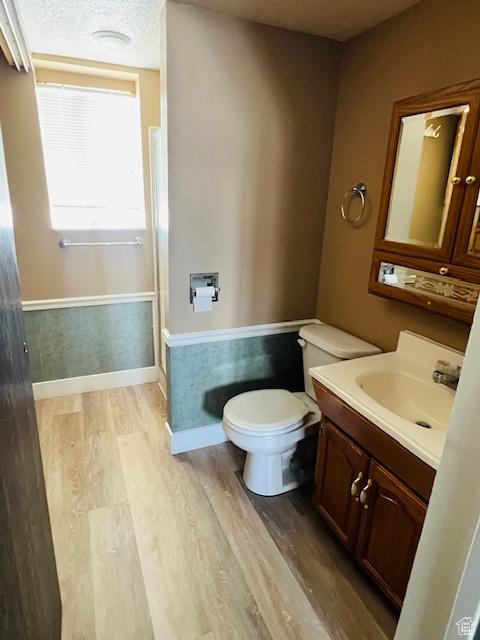 2299 W 5950 S, Roy, UT 84067 - bathroom with wood finished floors, toilet, vanity, and baseboards