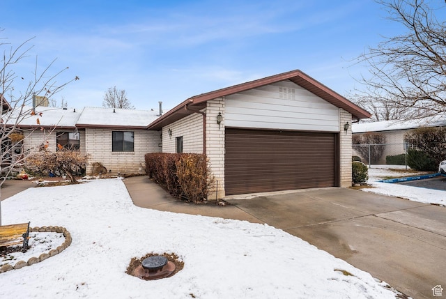 view of front of home with concrete driveway, an attached garage, and brick siding