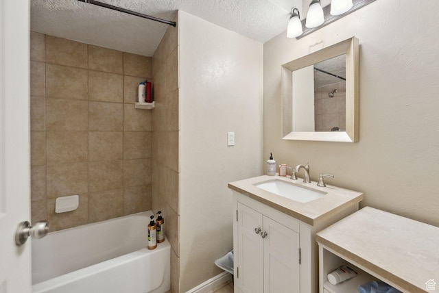bathroom with a textured ceiling, vanity, and shower / bath combination