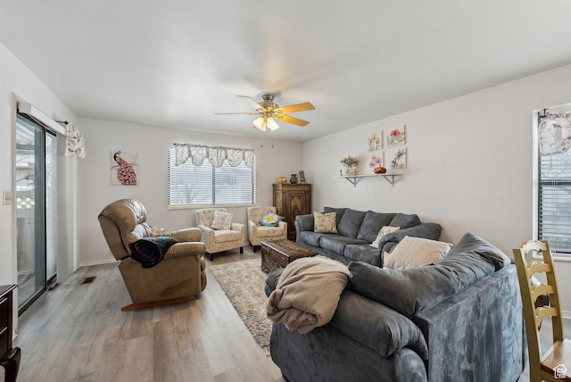 living area featuring visible vents, ceiling fan, light wood-style flooring, and baseboards