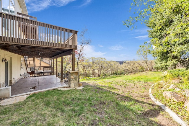 view of yard with a wooden deck and a patio area