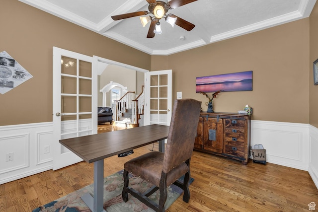 home office featuring wainscoting, ceiling fan, french doors, and wood finished floors