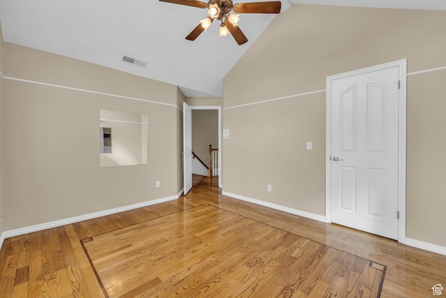 unfurnished room with visible vents, a ceiling fan, baseboards, light wood-style flooring, and high vaulted ceiling
