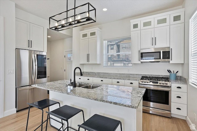 3543 N Creekside Way E Unit 63, Eden, UT 84310 - kitchen featuring a center island with sink, white cabinets, glass insert cabinets, stainless steel appliances, and a sink