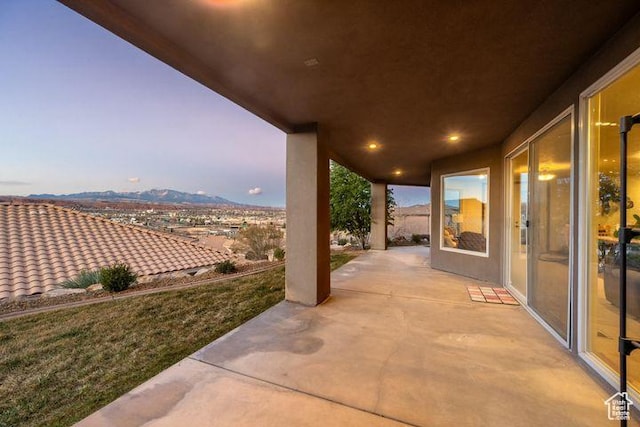 patio terrace at dusk featuring a mountain view