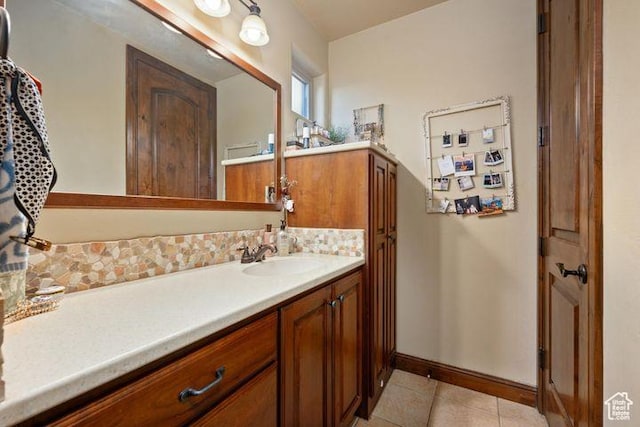 bathroom with tasteful backsplash, tile patterned flooring, vanity, and baseboards