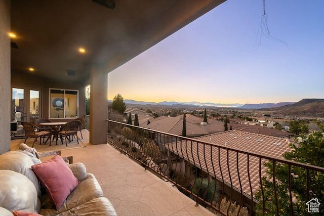 balcony with outdoor dining space, a mountain view, and a residential view